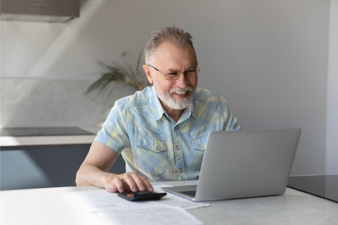 Na foto, imagem de uma homem idoso usando o computador.