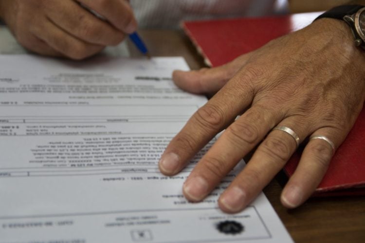 cropped-image-man-signing-paperwork-table